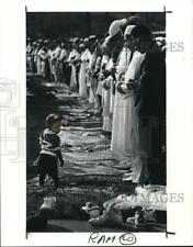 1990 Press Photo William Baldwin Jr checks out shoes discarded by Muslims